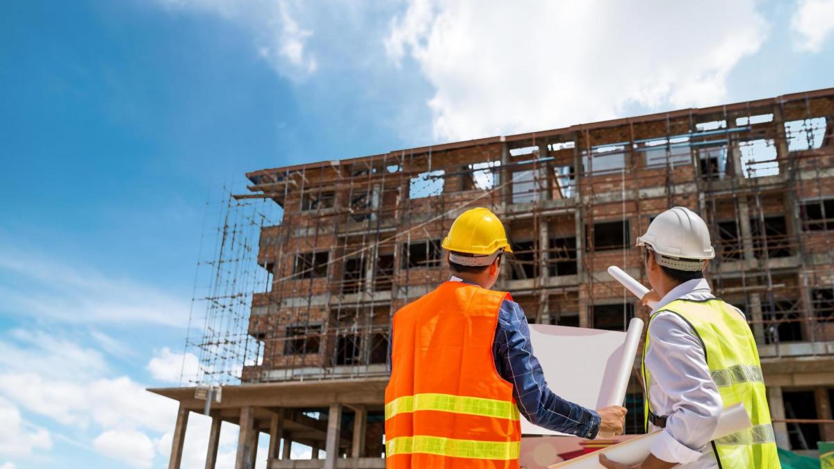 2439960 homme d affaires et ingenieur regardant un plan de batiment sur un chantier de construction de gratte ciel gratuit photo